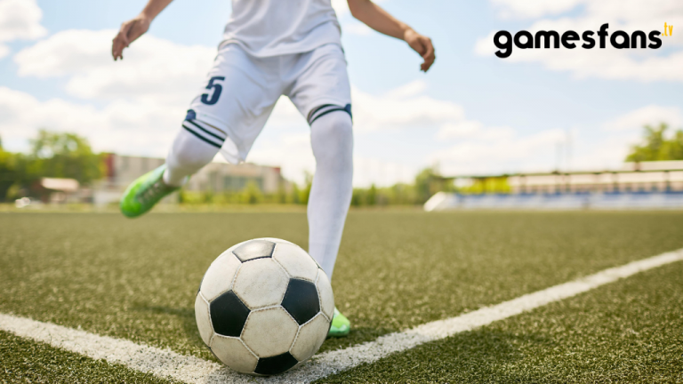 A boy kicking the football.