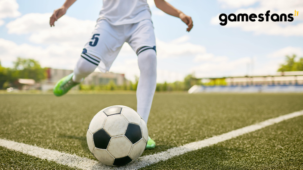 A boy kicking the football.